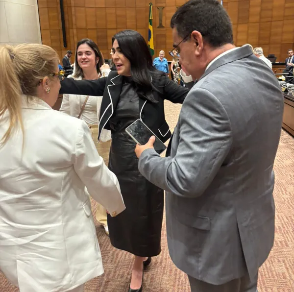 María Lívia comemorando no auditório no dia de sua aprovação comemorando com seus pais